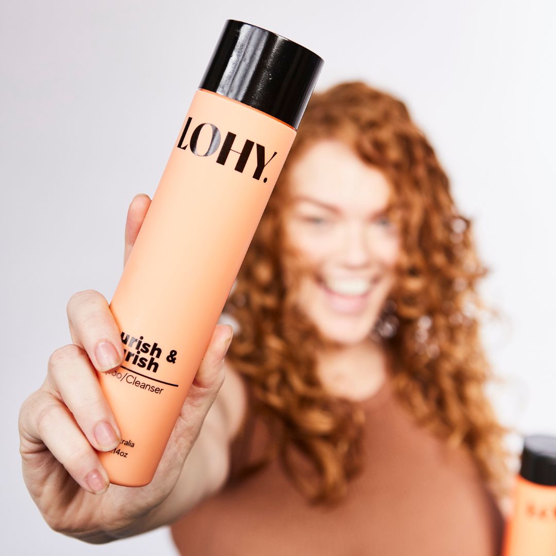 Person with 2c curls holding a bottle of curly hair shampoo
