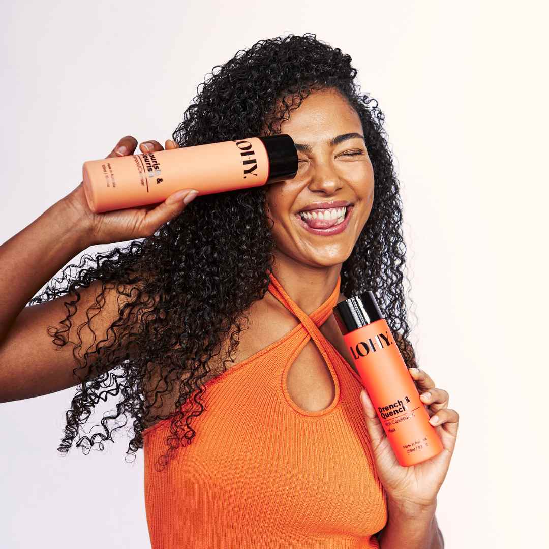 Person with 4a curls holding a bottle of curly hair shampoo
