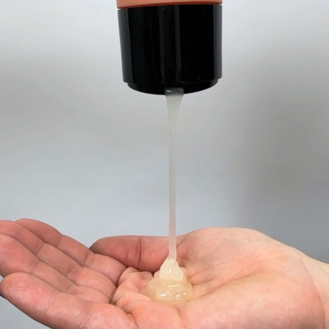 Curly hair shampoo being poured into palm of hand